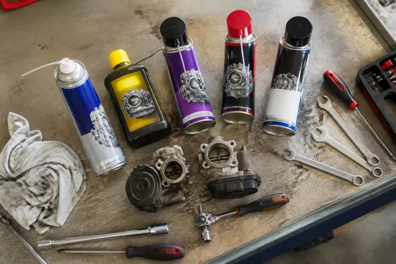 Assortiment de nettoyants vanne EGR, additifs et sprays, avec outils, dans un atelier automobile français.