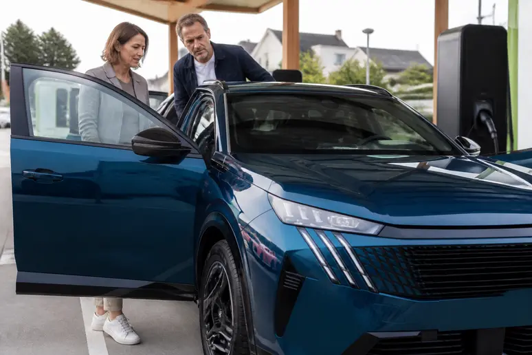 Couple observant la nouvelle Peugeot 3008 dans une station de recharge