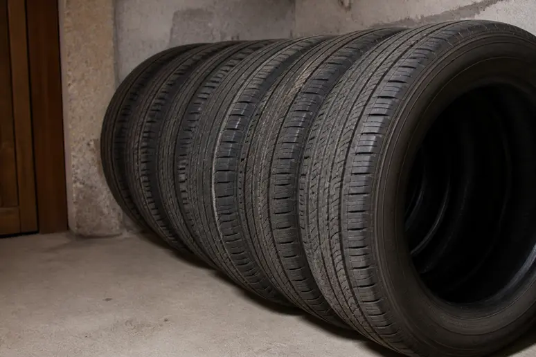 Pneus rangés verticalement dans un garage sec, conditions idéales pour stocker ses pneus dehors.