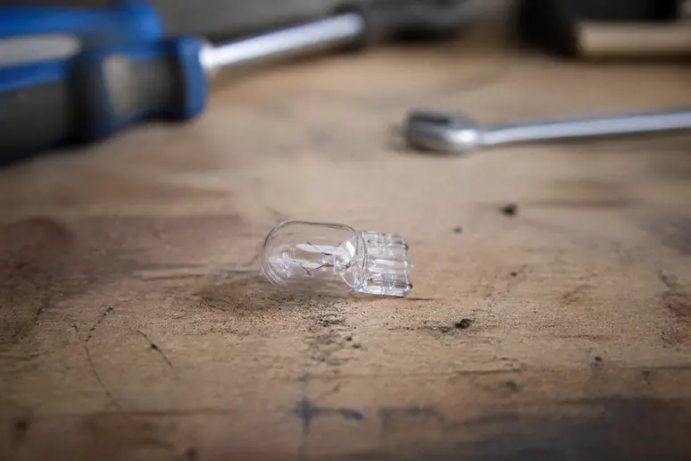 Ampoule w5w t10 posée sur un établi dans un atelier de mécanique automobile
