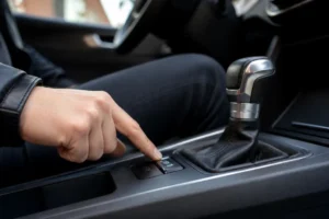 Conducteur actionnant le bouton Auto Hold fonctionnement sur la console centrale d'une voiture moderne