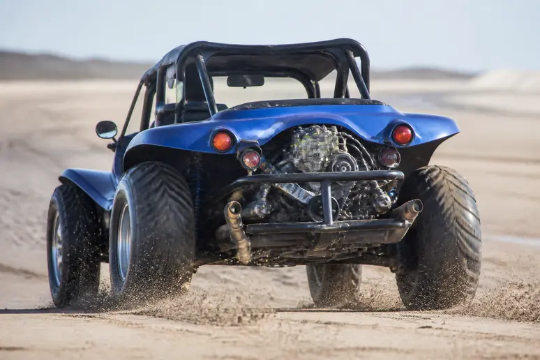 Buggy tout-terrain à roues larges évoluant sur une piste en sable