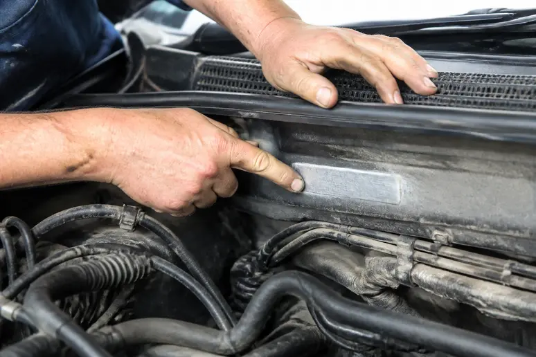 Inspection minutieuse du numéro de série gravé sur le châssis d'une voiture d'occasion