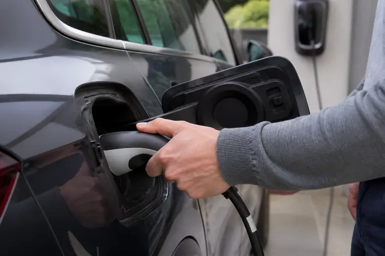 Branchement d'un câble de recharge sur la prise d'une voiture hybride rechargeable à domicile