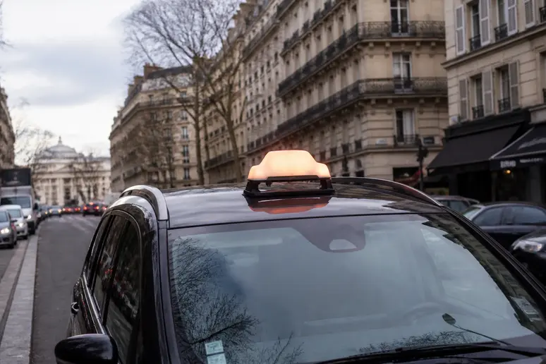 Voiture de taxi stationnée en milieu urbain avec son lumineux de signalisation sur le toit