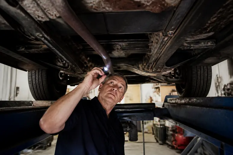 Inspection minutieuse des longerons et du châssis d'une ancienne Renault 12