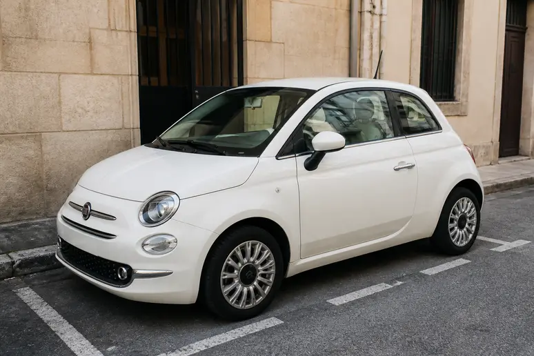 Une Toyota iQ garée dans une rue étroite démontrant son gabarit ultra réduit.