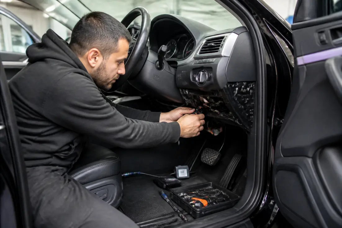 Un technicien installe un système antivol pour choisir alarme voiture dans un atelier automobile moderne.