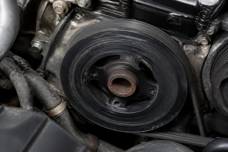 Poulie damper fixée sur le vilebrequin dans le compartiment moteur d'une voiture