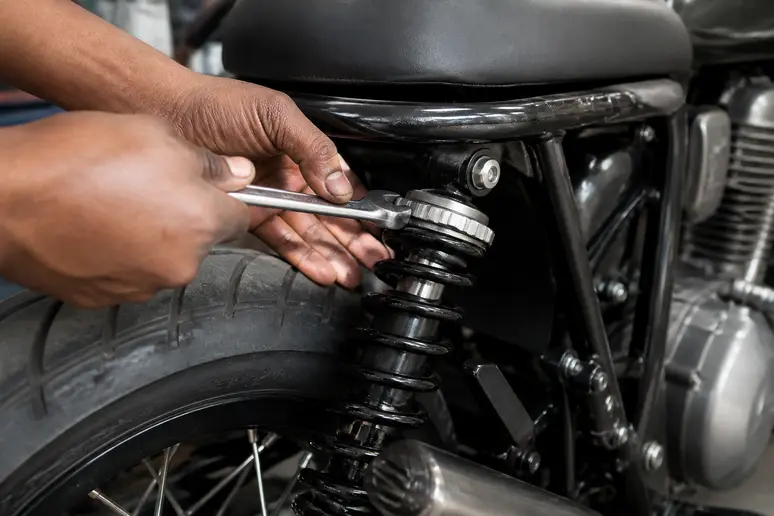Réglage de la précharge de l'amortisseur arrière d'une Royal Enfield Hntr 350 avec une clé à ergot