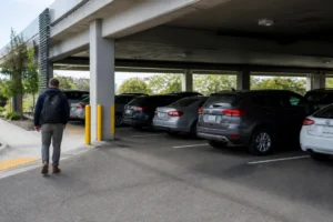 Un automobiliste marche près de son véhicule dans un parking vinci autoroutes la chapelle saint mesmin moderne.