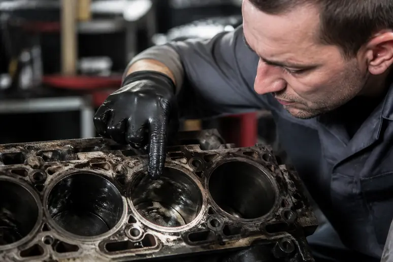 Mécanicien inspectant un cylindre moteur affecté par une dilution d'huile liée au carburant