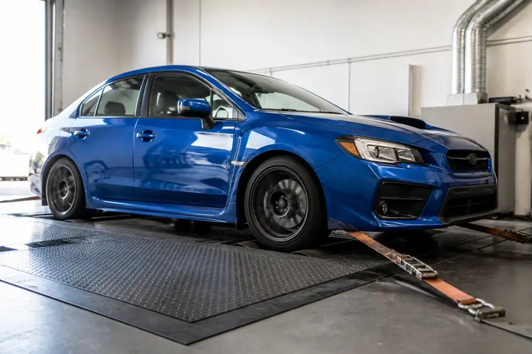 Subaru WRX fixée sur un banc de puissance à rouleaux en atelier de préparation