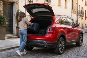 Un crossover compact rouge garé en ville illustre la dimension fiat 500x et son coffre.