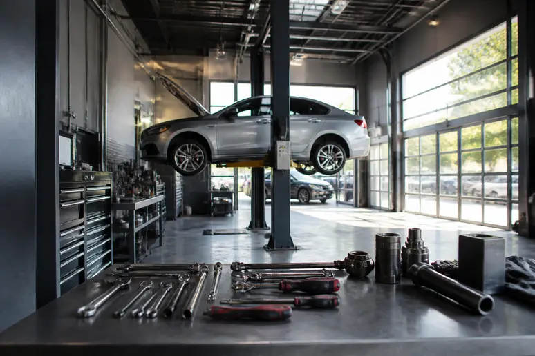 Centre d'entretien automobile moderne avec pont élévateur et outils de diagnostic professionnel