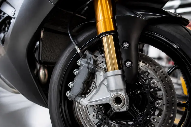 Gros plan sur les étriers de frein et la fourche d'une moto sportive haut de gamme