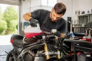 Mécanicien versant du liquide pour choisir liquide refroidissement moto dans le réservoir d'une sportive en atelier
