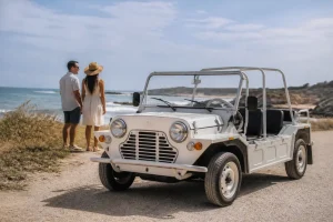 Une Mini Moke plage armée civil stationnée sur un chemin côtier ensoleillé.